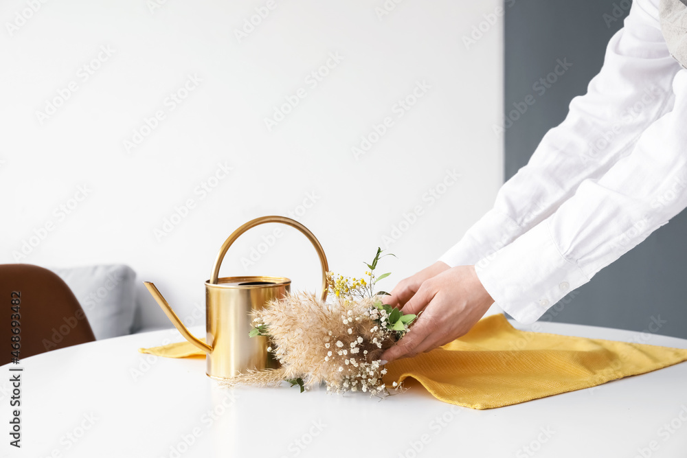 女人从桌子上拿着一束漂亮的干花，特写