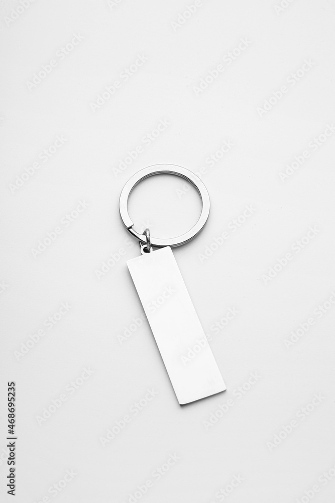 Stylish steel keychain on light background