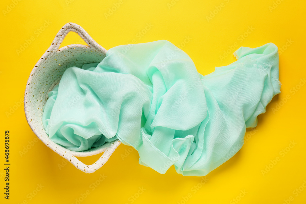 Basket with cloth on yellow background