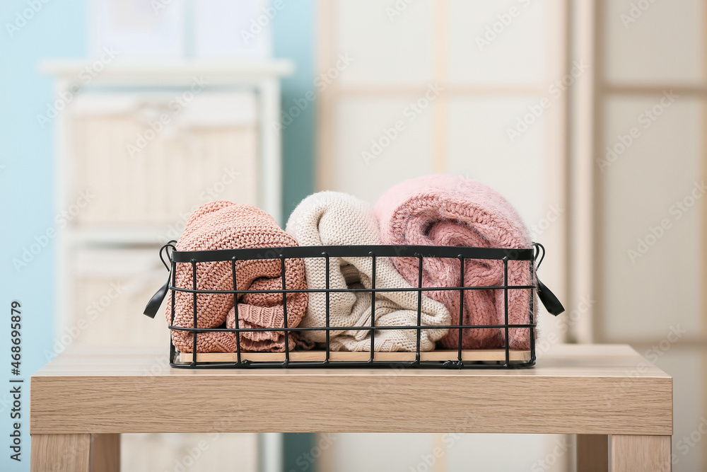 Basket with clean clothes on table in room