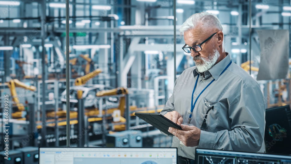 Car Factory Office: Portrait of Senior White Male Chief Engineer Using Tablet Computer in Automated 