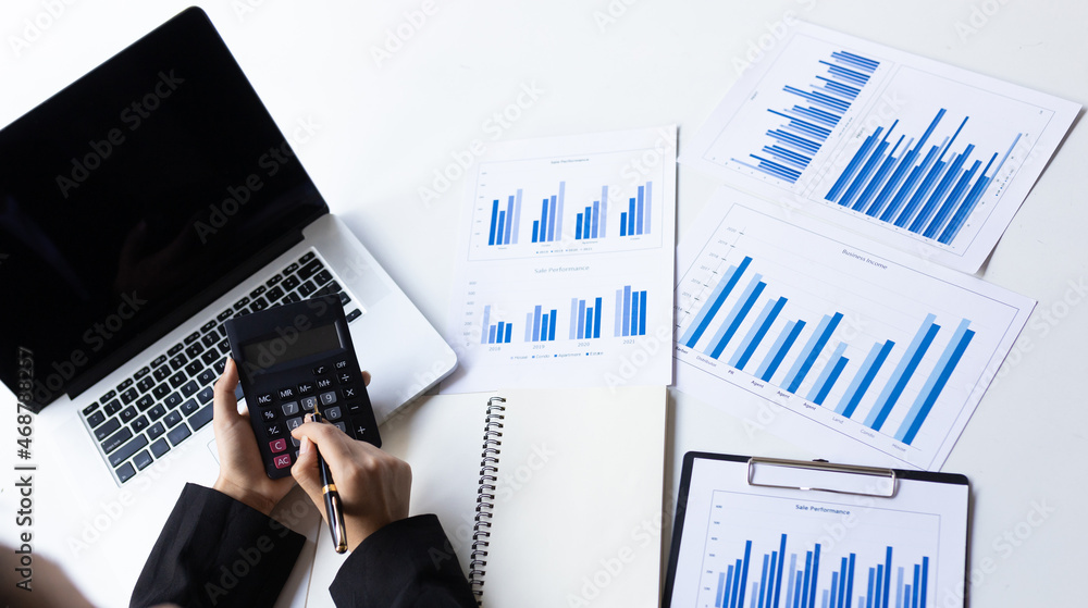 Businessman holding a calculator calculating accounting and analyzing business.