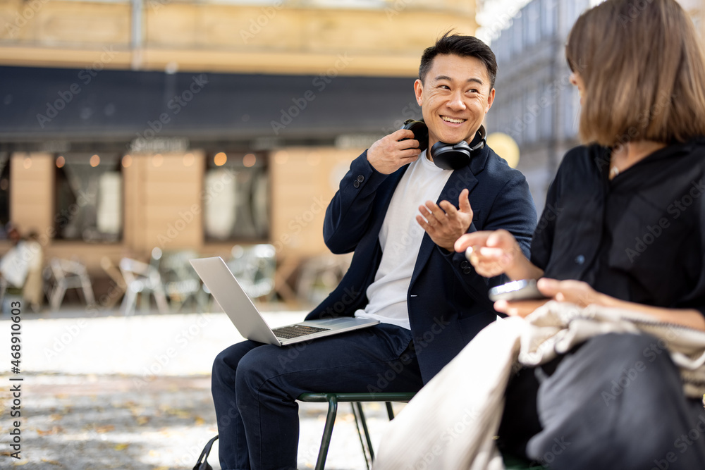 亚洲男人和年轻女人谈论城市地区。远程工作和自由职业的概念。商业的想法