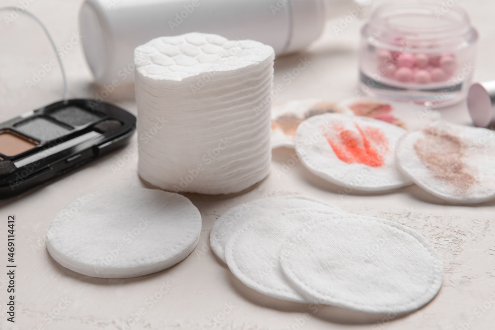 Clean and used cotton pads on light table, closeup