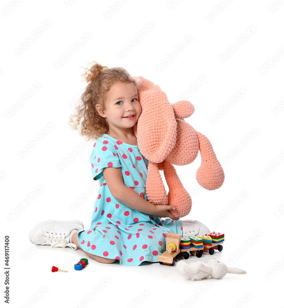 Cute baby girl playing with toys on white background