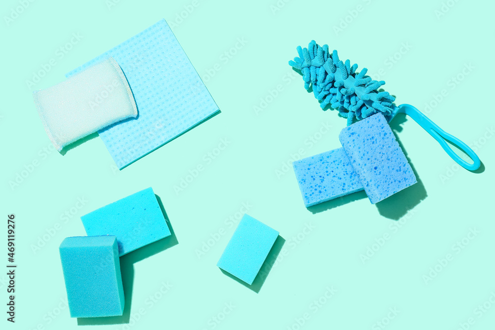 Different cleaning sponges and rag on color background