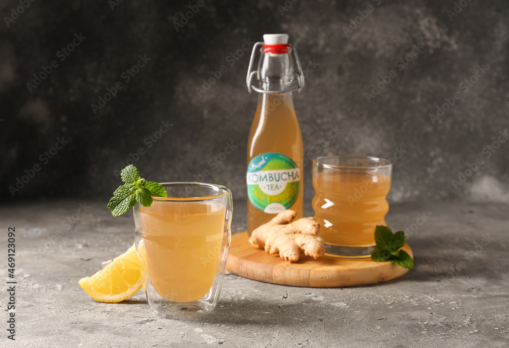 Bottle and glasses of fresh kombucha on table