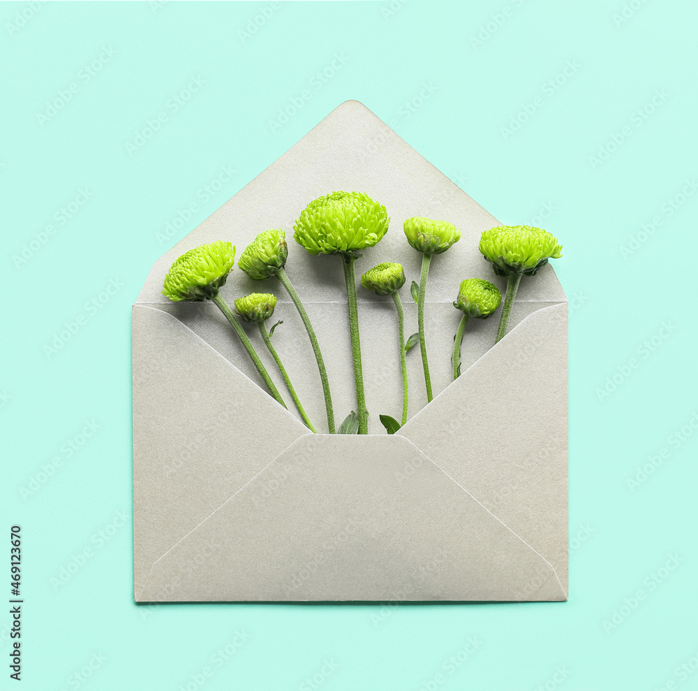 Envelope with green chrysanthemum on color background