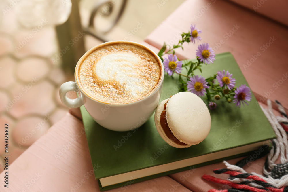 Cup of tasty coffee and notebook on table in outdoor cafe