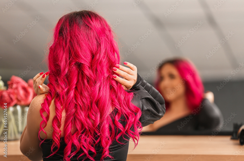 Young woman with bright hair color in beauty salon