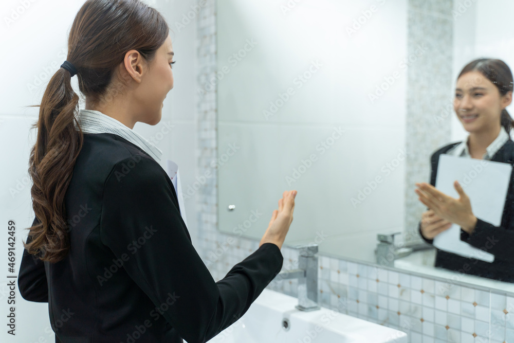 Asian applicant prepare for job interview in front of mirror at home.