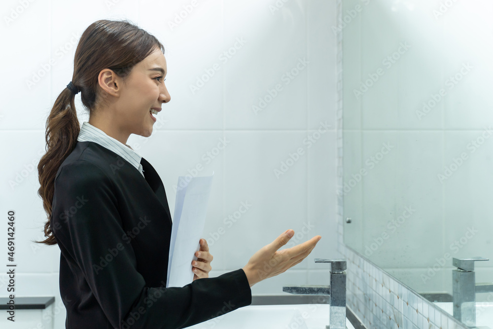 Asian applicant prepare for job interview in front of mirror at home.