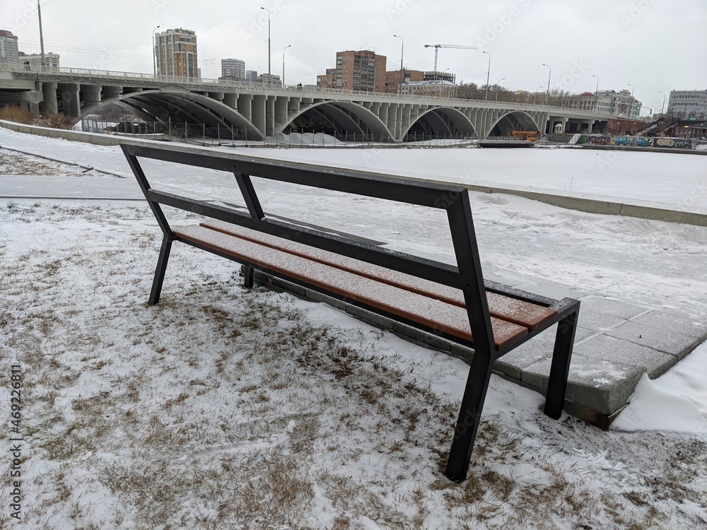 在建桥梁背景下的积雪长椅