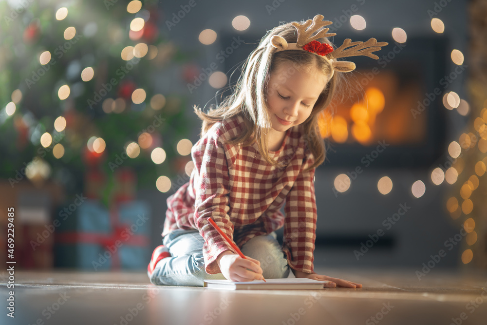 girl is writing the letter to Santa