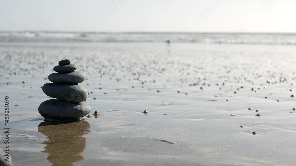 海滩上的岩石平衡，海浪堆起的石头。沙滩上的卵石金字塔