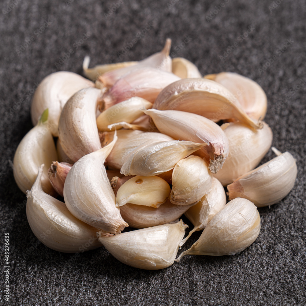 Fresh garlic cloves on black table background.