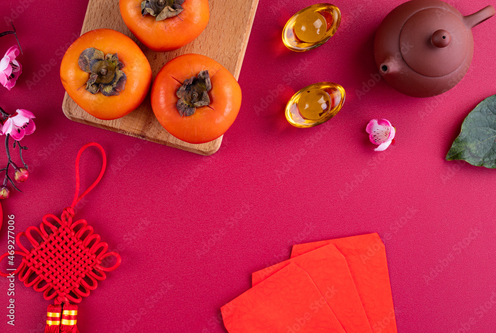 Top view of fresh sweet persimmons with leaves on red table background for Chinese lunar new year