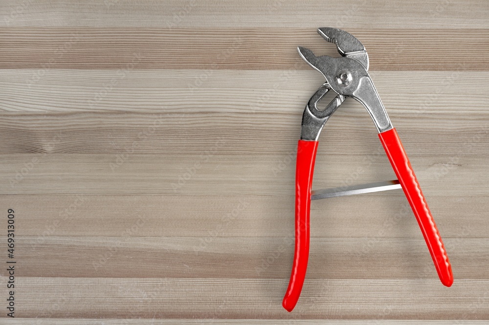 Tools, open carpenters pincers with handles on the desk