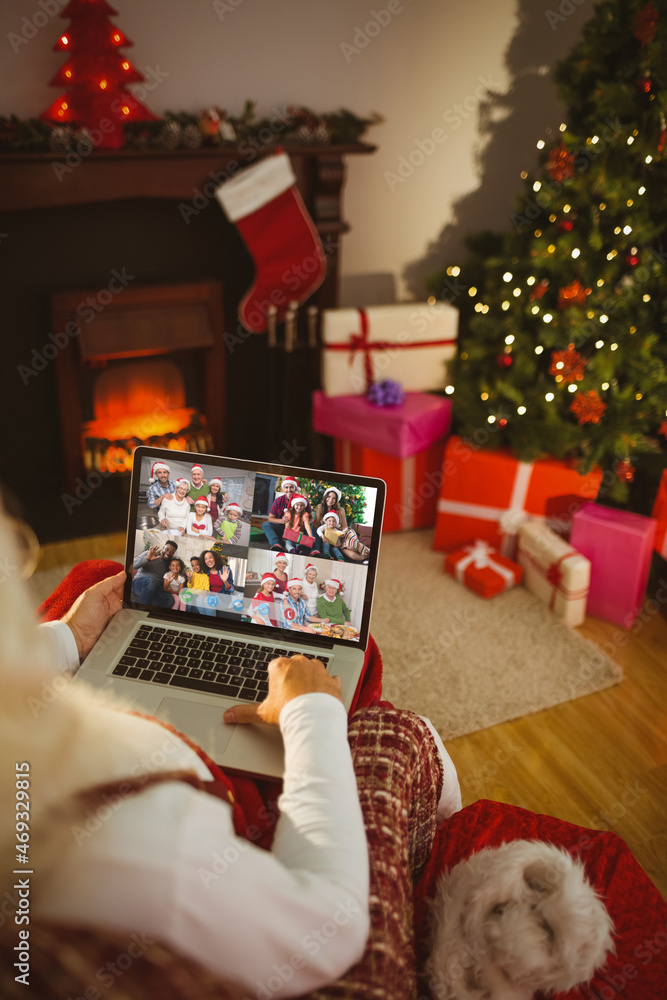 Santa claus making laptop christmas group video call with four diverse families