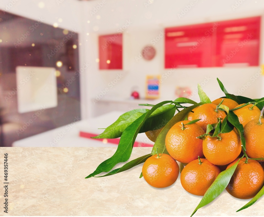 Fresh mandarin oranges fruit or tangerines with leaves on a desk