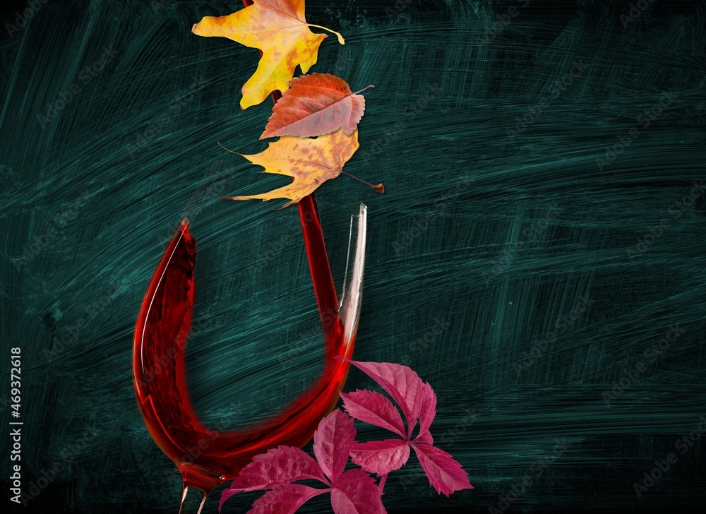 Wine glass with red wine and autumn leaves. Creative wine degustation