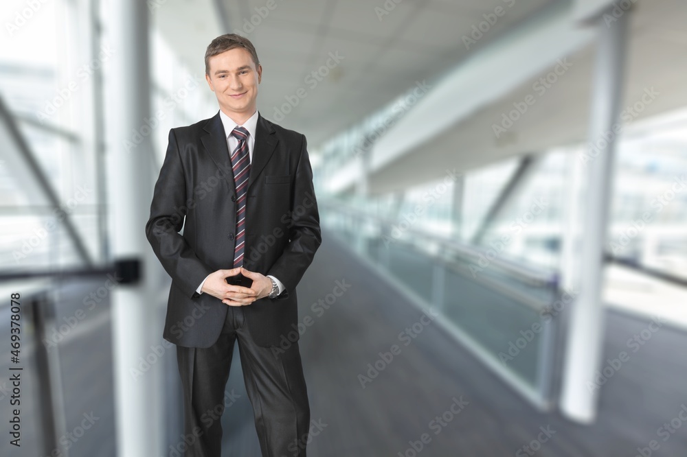 Smiling mature businessman in an office. Businessman looking at the camera while standing alone in a