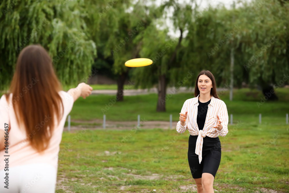 美丽的年轻女子在户外玩飞盘