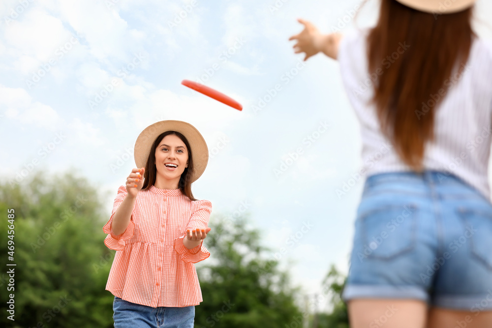 美丽的年轻女子在户外玩飞盘