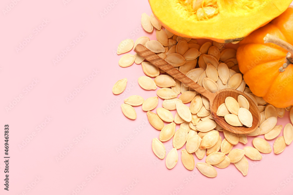 Pile of natural pumpkin seeds and fresh vegetables on light background, closeup