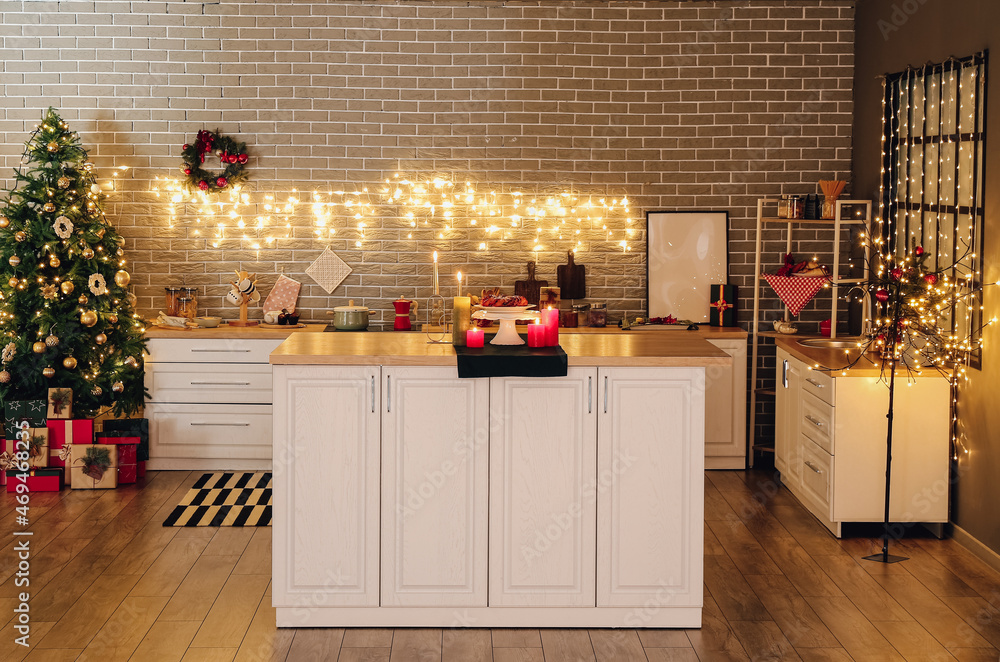 Interior of modern kitchen with Christmas decor, garland and candles