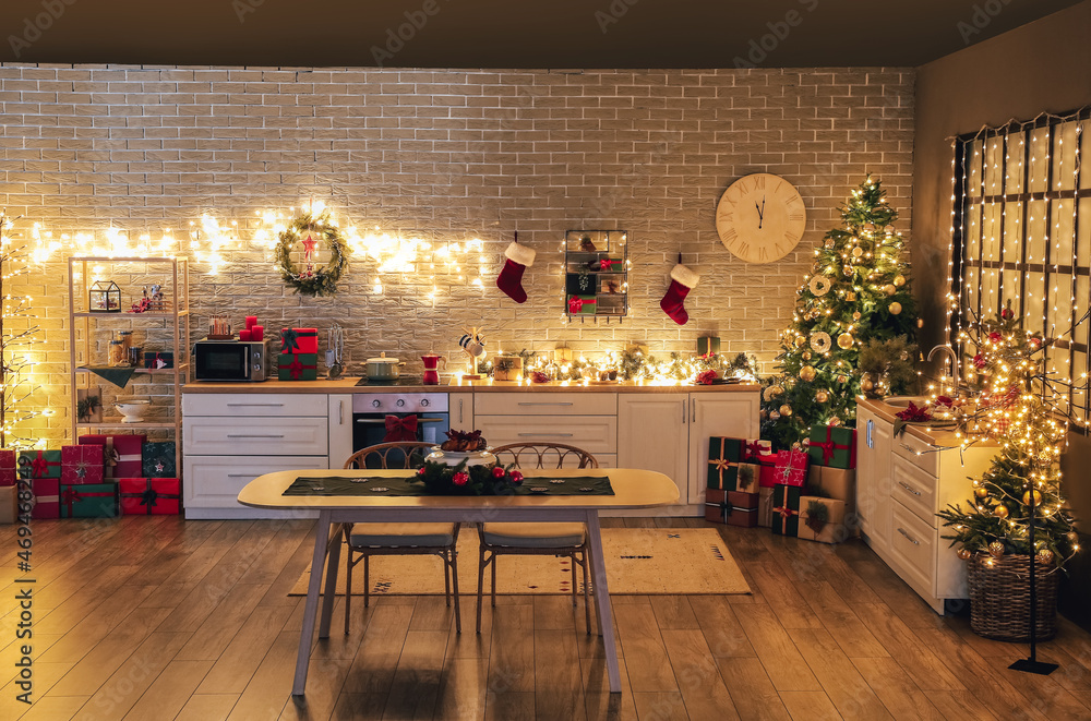 Interior of kitchen with Christmas tree, gift boxes, decor and dining table