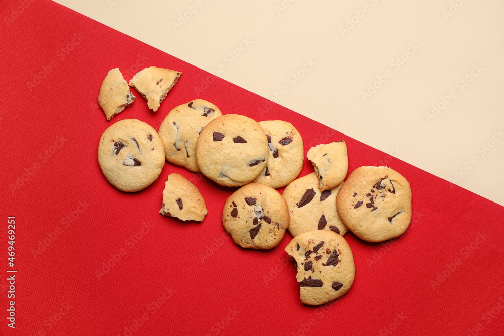 Delicious cookies with chocolate chips on color background