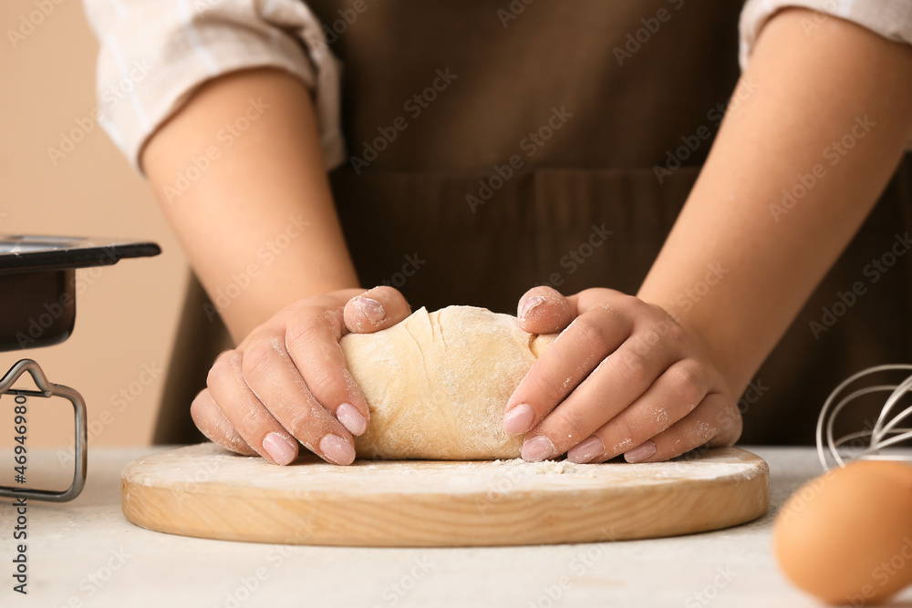 Woman preparing dough for homemade cookies at kitchen table, closeup