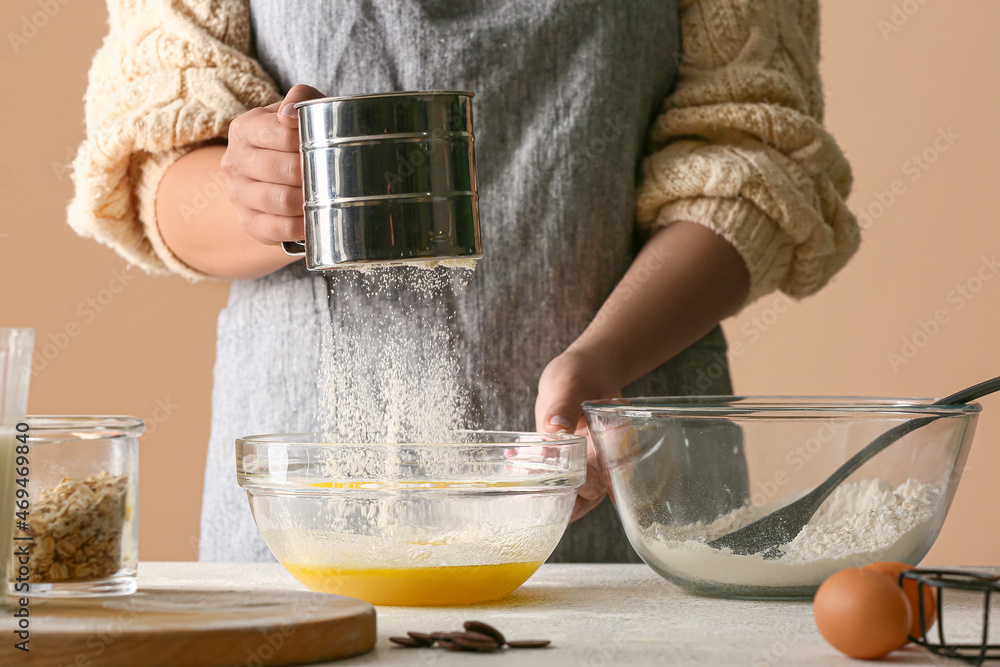 Woman preparing dough for homemade cookies at kitchen table, closeup