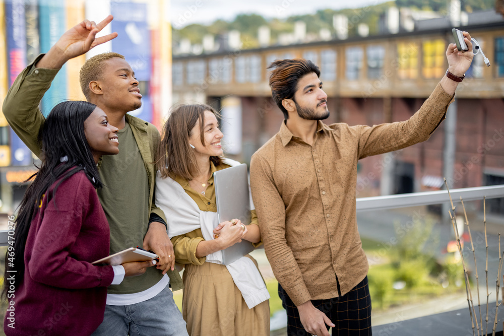 Multiracial students taking selfie on smartphone outdoors. Concept of education and learning. Idea o