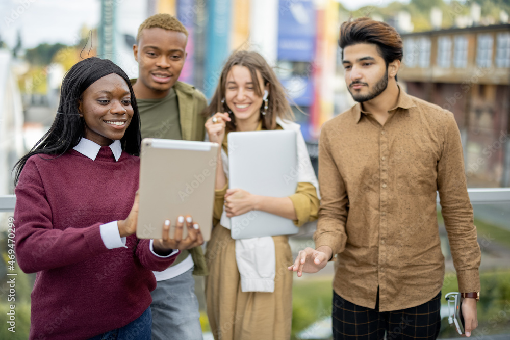 Multiracial students watching something on digital tablet outdoors. Concept of education. Remote and