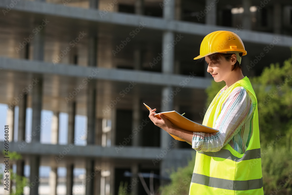 女建筑工人戴安全帽，户外文件夹