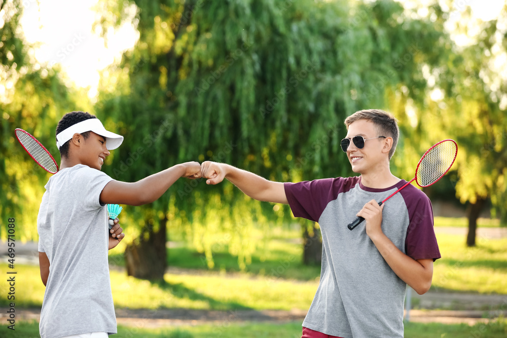 Male badminton players bumping fists in park