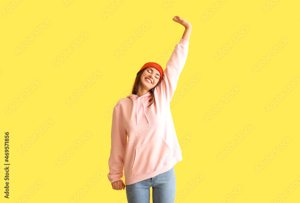 Beautiful young woman in stylish hoodie on color background