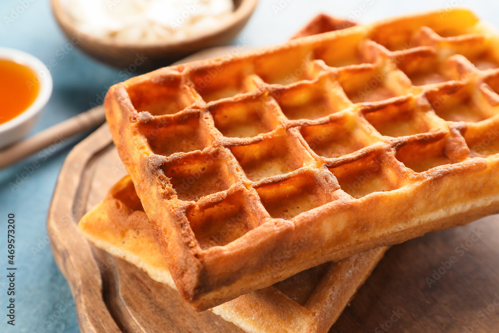 Board with yummy Belgian waffles on table, closeup