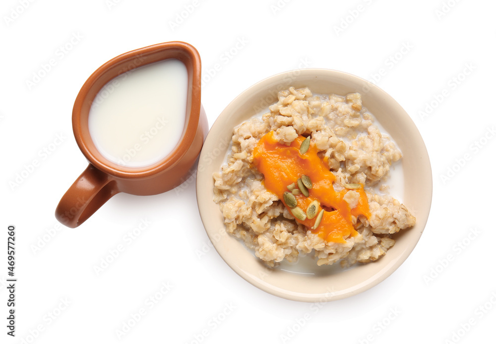 Bowl of tasty oatmeal with pumpkin and milk on white background