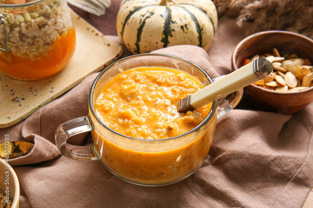 Pot of tasty oatmeal with pumpkin on table