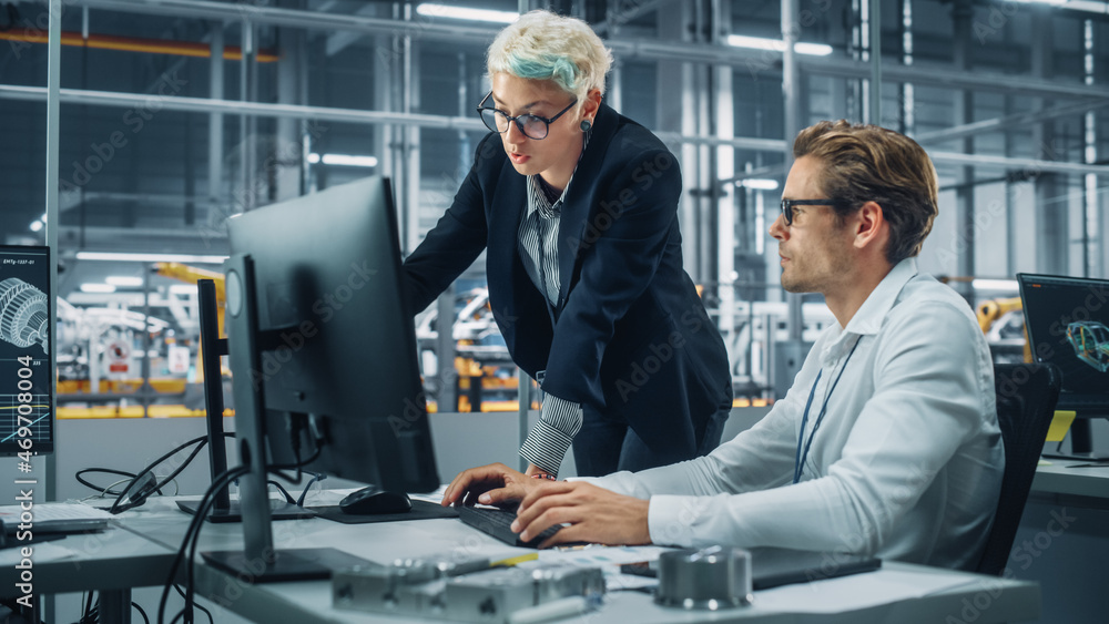 Two Automotive Engineers Discussing Concept Car Blueprints on Desktop Computer in Modern Office at A