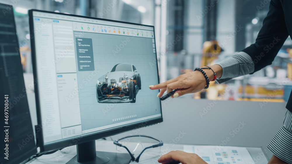 Two Automotive Engineers Discussing Concept Car Blueprints on Desktop Computer in Modern Office at A