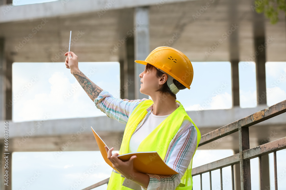 女建筑工人戴安全帽，户外文件夹