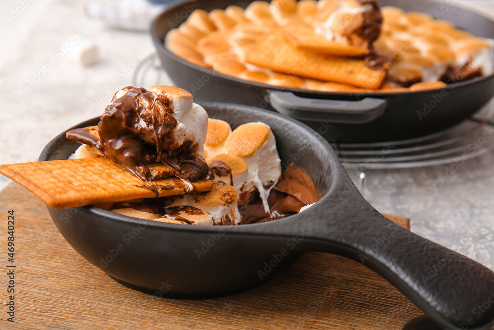 Frying pan with tasty Smores dip on table, closeup