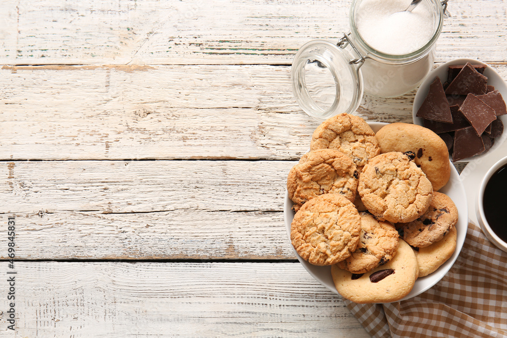 Bowl with tasty homemade cookies with chocolate chips on white wooden background