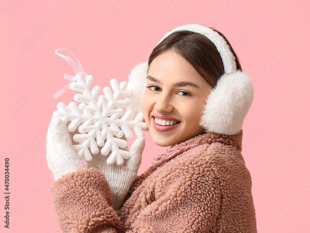 美丽的年轻女子，带着雪花和蓬松的彩色耳机