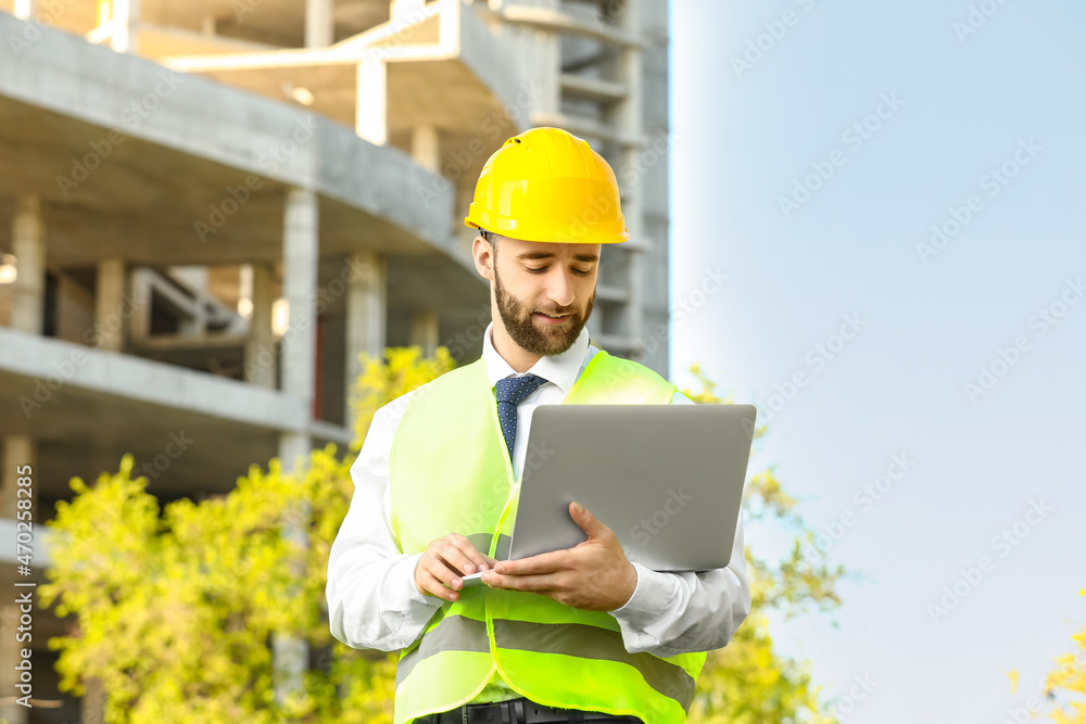 Construction worker using laptop outdoors