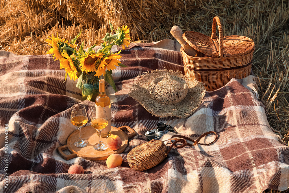 Festive picnic with sunflowers and wine on wheat field